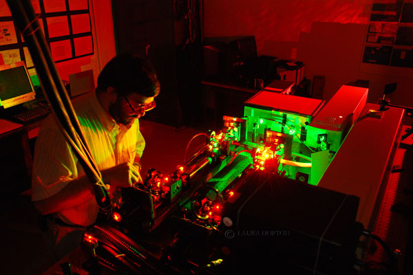 Research student studying laser equipment